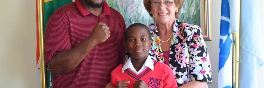 Akhule Mgoqi, a grade five learner at Zwelihle Primary School happily shows off his boxing moves to Executive Mayor Nicolette Botha-Guthrie, while his coach and owner of Overstrand Whale Boxing Club looks on proudly.